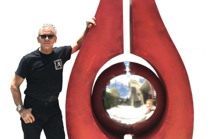 Fotografía promocional cedida donde aparece el escultor cubano-estadounidense Armando Pérez Alemán junto a su escultura "Longina I". Foto: EFE / Cortesía Armando Pérez Alemán.