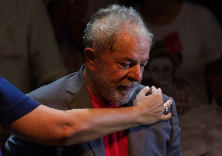 El expresidente de Brasil Luiz Inácio Lula da Silva recibe un abrazo durante un acto de campaña con miembros de su Partido de los Trabajadores y otros líderes de izquierdas en Río de Janeiro, el 2 de abril de 2018. Pese a encontrarse ahora en prisión, Lula es el favorito para las presidenciales de octubre. Foto: Leo Correa / AP.