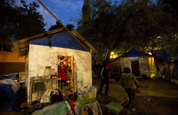 Miembros de la familia Márquez hablan afuera del albergue temporal donde siete niños y cuatro adultos de la familia viven en un parque, seis meses después de que un terremoto dañó el complejo habitacional Multifamiliares Tlalpan. Foto: Rebecca Blackwell / AP.