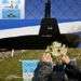 Una mujer coloca flores sobre una imagen recortada del submarino ARA San Juan en la valla de la base naval en Mar de Plata, Argentina. Foto: Esteban Felix / AP.