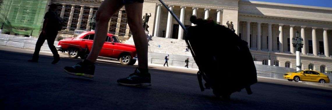 Una turista camina con su maleta por delante del Capitolio, en La Habana, Cuba. Foto: Ramón Espinosa / AP.