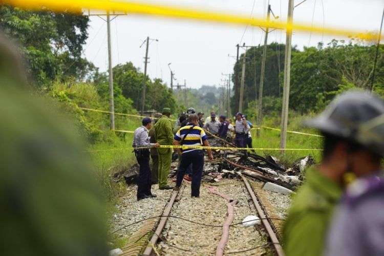 Trabajadores de rescate donde el avión cayó. Foto: Ramón Espinosa / AP.