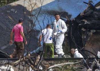 Forenses y agentes del ministerio del Interior remueven los restos de un Boeing 737 que cayó en un campo de yuca con más de 100 personas a bordo poco después de despegar de La Habana, Cuba, 18 de mayo de 2018. Foto: Desmond Boylan/AP.