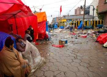 Vendedores callejeros cerca del lugar donde explotó un cilindro de gas en Oruro, Bolivia, que provocó ocho fallecidos y 40 heridos. Foto: Juan Karita / AP.