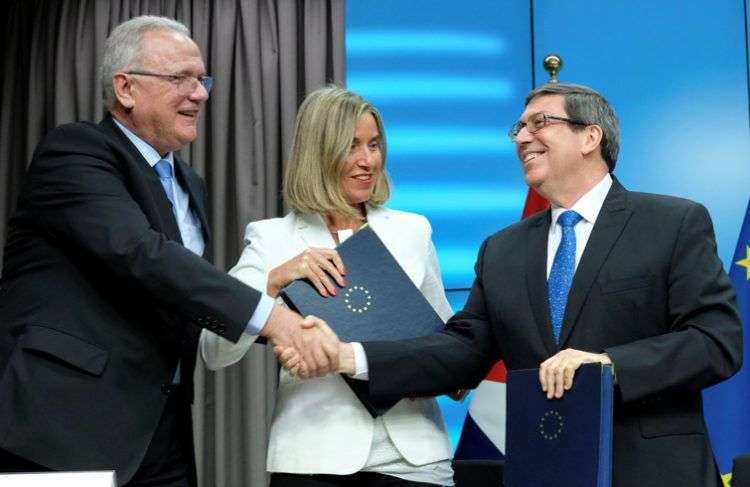 El comisario europeo de Cooperación Internacional y Desarrollo, Neven Mimica (izq), y la jefa de la diplomacia europea, Federica Mogherini, intercambian documentos con el canciller cubano, Bruno Rodríguez, tras la firma de un acuerdo de energías renovables como parte del Primer Consejo Conjunto entre ambas partes, celebrado en Bruselas, Bélgica. Foto: Olivier Hoslet / EFE.