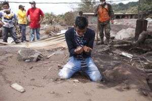 Bryan Rivera llora sobre los restos de su casa después de que su familia desapareciera tras la erupción del Volcán de Fuego en San Miguel Los Lotes, Guatemala. Foto: Moisés Castillo / AP.