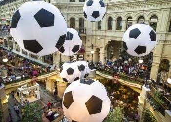 Turistas y aficionados del fútbol caminan por el centro comercial GUM decorado con enormes balones de fútbol con motivo del Mundial en Moscú, Rusia. Foto: Alexander Zemlianichenko/AP.