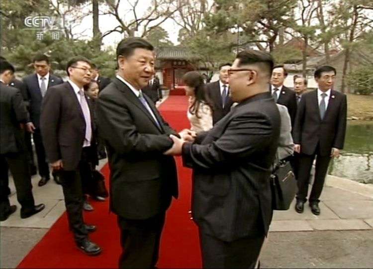 El líder norcoreano Kim Jong Un, derecha, y su contraparte chino Xi Jinping, se estrechan las manos en la casa de huéspedes del estado Diaoyutai en Beijing, el 28 de marzo de 2018. Foto: CCTV vía AP Video.