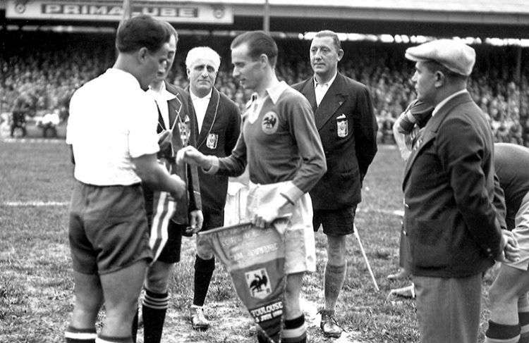 El futbolista cubano Manuel Chorens saluda al rumano Gheorghe Rasinaru frente a los árbitros, antes del inicio de uno de los partidos entre Cuba y Rumanía en el Mundial de Francia 38. Foto: goal.com