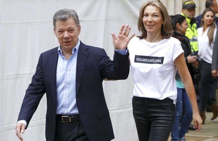 El presidente colombiano Juan Manuel Santos saluda acompañado de su esposa María Clemencia Rodríguez antes de votar en los comicios presidenciales en Bogotá, Colombia, el pasado 17 de junio de 2018. Foto: Daniel Muñoz / AP.