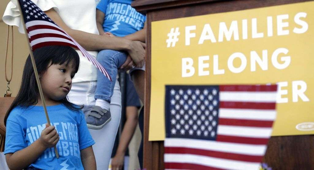 Andrea Elena Castro, hija del representante demócrata Joaquin Castro, sostiene una bandera durante un evento para protestar por la nueva política migratoria que ha derivado en la separación de familias, el jueves 31 de mayo de 2018, en San Antonio. Foto: Eric Gay / AP.