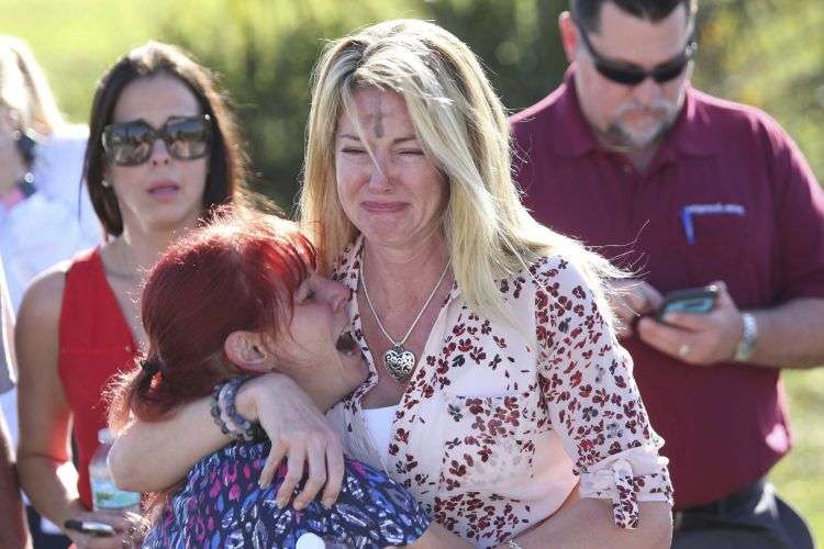 Padres esperan por noticias tras el reporte de un tiroteo en la Escuela Secundaria Marjory Stoneman Douglas de Parkland, Florida. Foto: Joel Auerbach / AP.