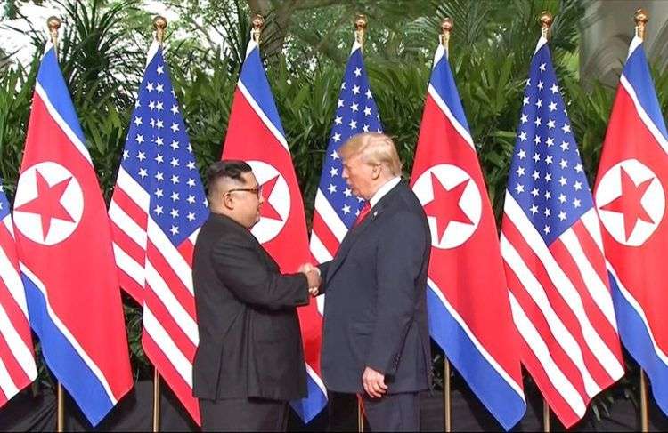 Donald Trump y al mandatario norcoreano Kim Jong Un se estrechan la mano antes del inicio de su reunión en el Hotel Capella de Singapur este martes 12 de junio de 2018. Imagen tomada del video de Host Broadcaster Mediacorp Pte Ltd vía AP.