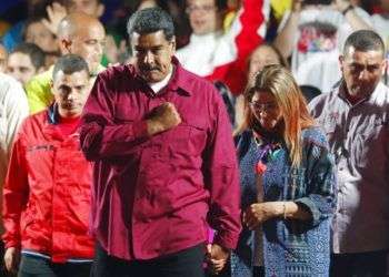 El presidente de Venezuela, Nicolás Maduro, se lleva el puño al corazón a su llegada, acompañado por su esposa Cilia Flores, a un acto con seguidores después de su reelección para un segundo mandato en las elecciones presidenciales, en Caracas, Venezuela, el 20 de mayo de 2018. Foto: Ariana Cubillos/AP.