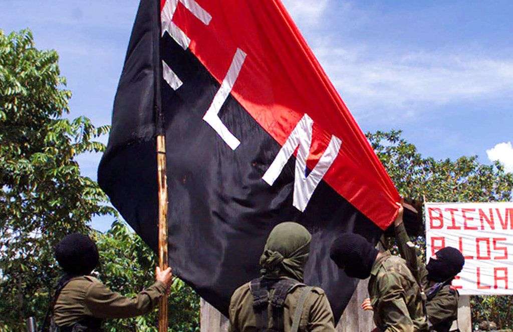 En esta foto del 12 de octubre de 1998, miembros del Ejército de Liberación Nacional (ELN) levantan su bandera en San Francisco, región montañosa en el norte de Colombia. Foto: Fernando Llano / AP.