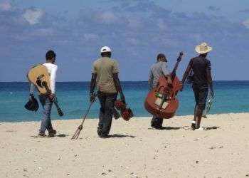 Grupo de soneros camina por playa turística en Cuba. Foto: www.pxhere.com