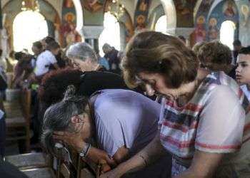 Fieles ortodoxos asisten a un funeral por las víctimas de un incendio, dentro de una iglesia en la localidad de Mati, al este de Atenas, el 29 de julio de 2018. Foto: Yorgos Karahalis/AP.