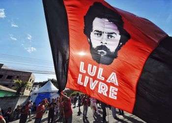 Un partidario del expresidente Luiz Inácio Lula da Silva ondea una bandera con la imagen del exmandatario frente a los cuarteles de la policía federal donde Lula cumple una sentencia de 12 años de prisión, el domingo 8 de julio de 2018. Foto: Denis Ferreira Netto / AP.