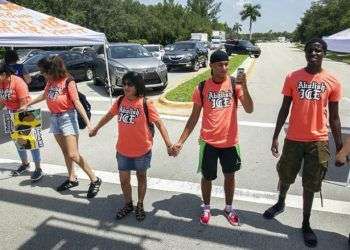 Manifestantes que lucen camisetas con la consigna "Hay que abolir el ICE" bloquean la intersección de la Avenita 145 y la Calle SW 29 en Miramar, Florida, el 18 de julio del 2018. Foto: C.M. Guerrero / Miami Herald vía AP.