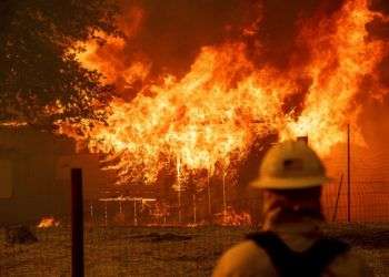 Un bombero controla un edificio en llamas para asegurarse de que no se expandan mientras el incendio River calcina parte de la ciudad de Lakeport, en California, el 30 de julio de 2018. Foto: Noah Berger / AP.