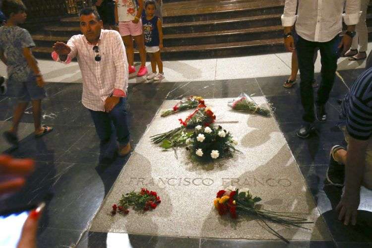 Un hombre hace un saludo con el brazo en alto junto a la tumba del ex dictador español Francisco Franco en la basílica del Valle de los Caídos cerca de El Escorial, en las afueras de Madrid, el viernes 24 de agosto de 2018. Foto: Andrea Comas / AP.