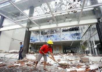 Trabajadores limpian los escombros en un edificio dañado por un potente sismo en Bali, Indonesia, este 6 de agosto de 2018. Foto: Firdia Lisnawati / AP.