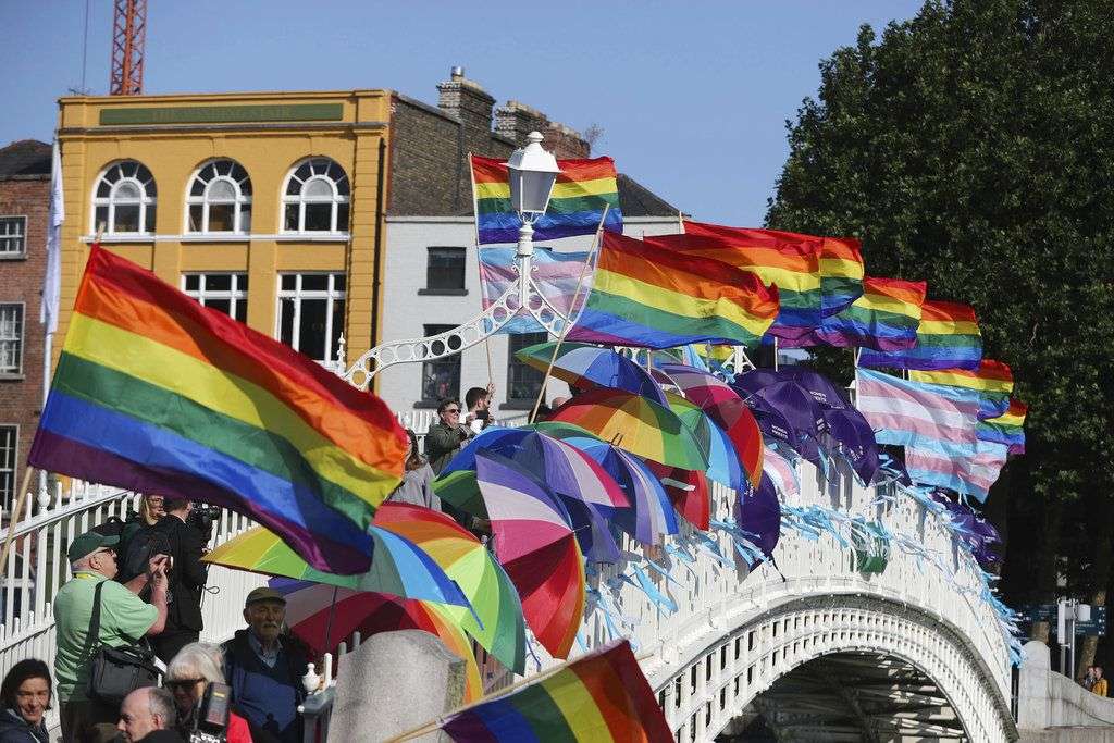 Banderas de arcoiris y cintas azules ondean con el aire en el puente Ha'Penny, en Dublín, para recordar a las víctimas de abuso sexual por parte de los clérigos de la Iglesia católica, antes de la llegada del papa Francisco Dublín, Irlanda, el sábado 25 de agosto de 2018. Foto: Niall Carson/PA/AP.