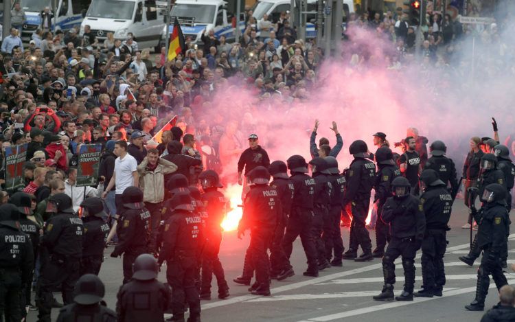 Manifestantes prenden petardos durante una manifestación en Chemnitz, Alemania, el lunes 27 de agosto de 2018. Foto: Jens Meyer / AP.