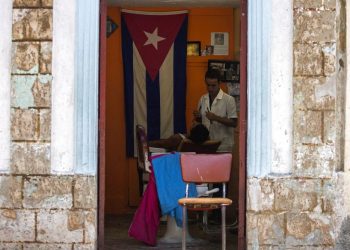 Un barbero rasura a un cliente en su negocio privado en La Habana, Cuba, el martes 10 de julio de 2018. Foto: Desmond Boylan / AP.