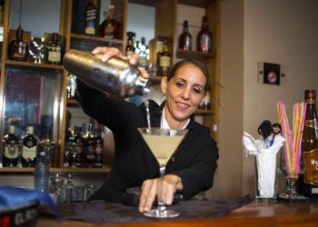 La cantinera cubana Bárbara Betancourt sirve un daiquiri en un bar de La Habana. Foto: Desmond Boylan / AP.