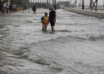 Unas personas caminan a través de una inundación causada por el tifón Mangkhut en Hong Kong, el domingo 16 de septiembre de 2018. Foto: Vincent Yu/AP.