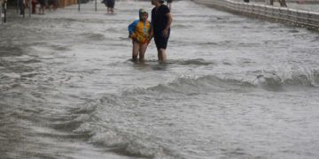 Unas personas caminan a través de una inundación causada por el tifón Mangkhut en Hong Kong, el domingo 16 de septiembre de 2018. Foto: Vincent Yu/AP.