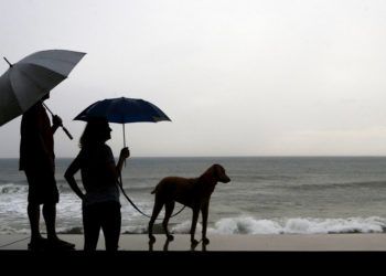 Una pareja y su perro, parados en la orilla antes de la llegada del huracán Willa, en Mazatlan, México, el 23 de octubre de 2018. Foto: Marco Ugarte / AP.