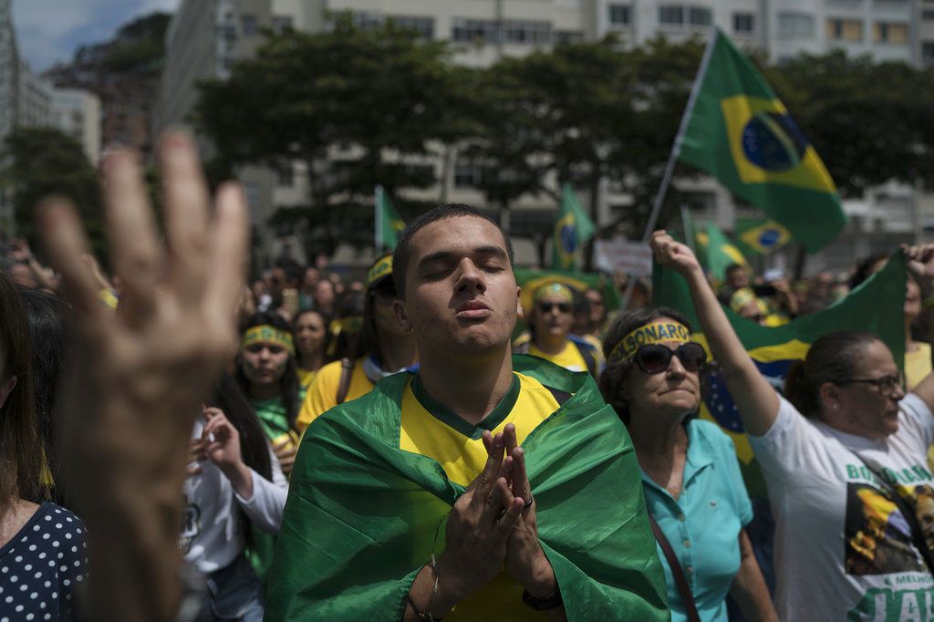 Una multitud escucha el himno nacional en el acto de campaña del candidato presidencial ultraderechista Jair Bolsonaro en Río de Janeiro, Brasil, el domingo 21 de octubre de 2018. Foto: Leo Correa / AP.