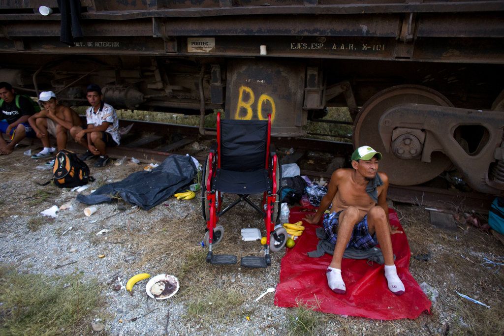 El migrante hondureño Sergio Cáseres, de 40 años, quien perdió su capacidad de caminar hace 20 años tras un accidente doméstico, descansa a un lado de su silla de ruedas mientras la caravana de migrantes centroamericanos se detiene para pasar la noche en Arriaga, México, el viernes 26 de octubre de 2018. (AP Foto/Rebecca Blackwell)