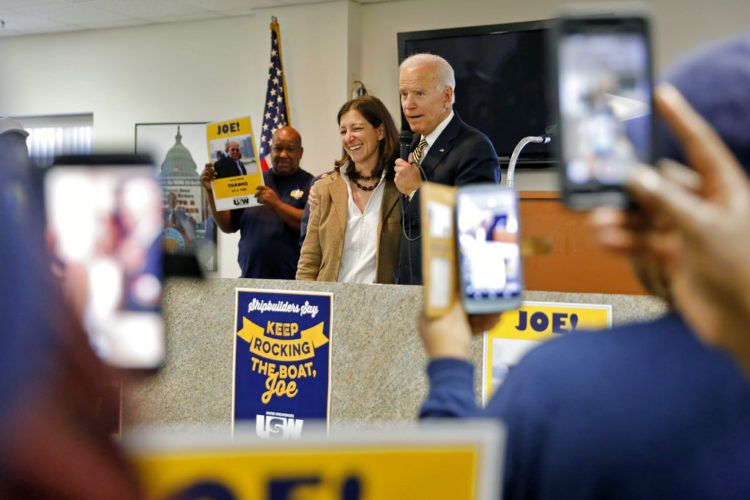 El ex vicepresidente Joe Biden abraza a Elaine Luria, cadidata demócrata por el Distrito 2 de Virginia, enfrente de trabajadores sindicalizados el viernes 19 de octubre del 2018 en Newport News, Virginia. Foto: Jonathon Gruenke/The Daily Press vía AP.