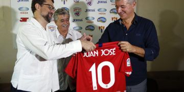 El consejero delegado del Club Atlético de Madrid, Miguel Ángel Gil Marín (d), entrega una camiseta del Club al embajador de España en Cuba, Juan Jose Buitrago (i), junto al comisionado nacional de Fútbol en Cuba, Luis Hernández (c), este martes 2 de octubre de 2018, en La Habana. Foto: Ernesto Mastrascusa / EFE.