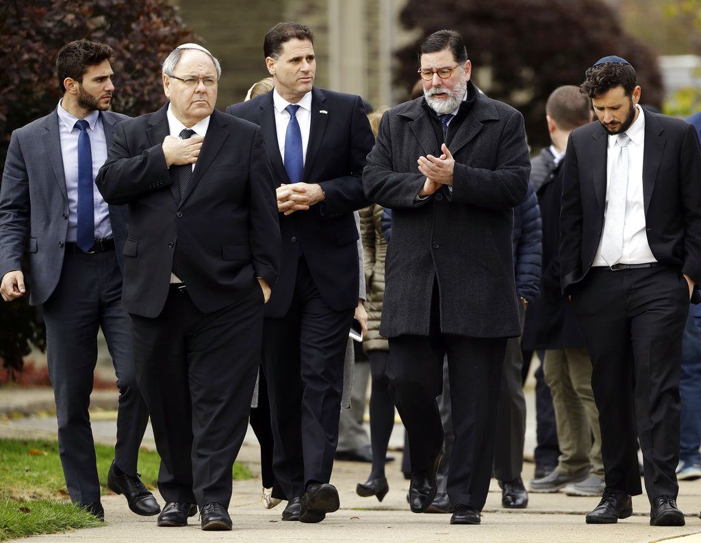 Bill Peduto, alcalde de Pittsburgh, segundo de derecha a izquierda, y el embajador israelí en Estados Unidos, Ron Dermer, tercero desde la derecha, caminan cerca de la sinagoga Árbol de la Vida en Pittsburgh, el domingo 28 de octubre de 2018, al día siguiente de una masacre allí Foto: Matt Rourke / AP.