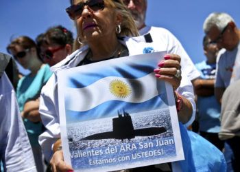 En esta imagen de archivo, tomada el 25 de noviembre de 2017, una mujer sostiene un cartel con el mensaje "Valientes del ARA San Juan, estamos con ustedes", delante de la base naval de la Armada en Mar del Plata, Argentina, donde se reunieron los familiares de los tripulantes desaparecidos en el sumergible. Foto: Esteban Félix / AP / Archivo.