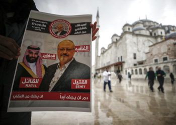 Un hombre sostiene un cartel que muestra imágenes del príncipe heredero saudí Muhammed bin Salman y del periodista Jamal Khashoggi, en el que se describe al príncipe como "asesino" y a Khashoggi como "mártir" durante un momento de oración por Khashoggi, asesinado en el consulado saudí el mes pasado en Estambul, el viernes 16 de noviembre de 2018. Foto: Emrah Gurel / AP.