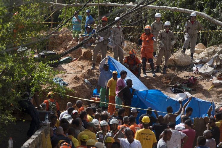 Vecinos, voluntarios y bomberos realizan tareas de búsqueda y rescate tras un deslizamiento en el morro Boa Esperança en Niteroi, Brasil, 10 de noviembre de 2018. Catorce muertos y 11 heridos es el resultado del deslizamiento, aunque las autoridades dijeron que podría haber más víctimas el domingo 11 de noviembre de 2018. (AP Foto/Leo Correa)