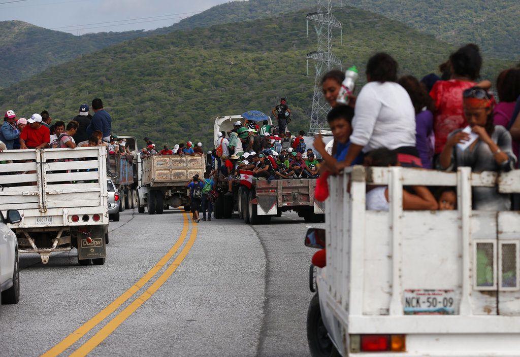 Migrantes se suben a las partes traseras de camiones mientras una caravana de miles de centroamericanos que esperan llegar a la frontera de Estados Unidos avanza desde Juchitán en el estado de Oaxaca, México, el jueves 1 de noviembre de 2018. (AP Foto / Rebecca Blackwell)