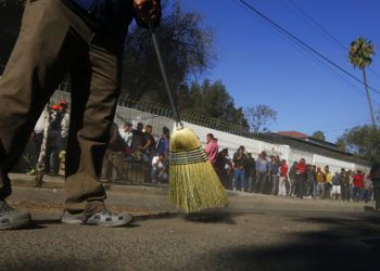 Migrantes centroamericanos barren afuera de un albergue en donde se quedan en Tijuana, México, el domingo 18 de noviembre de 2018. (AP Foto/Marco Ugarte)