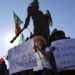 Manifestantes sostienen carteles bajo la estatua del emperador azteca Cuauhtémoc como protesta contra los miles de migrantes centroamericanos que han llegado a la ciudad en Tijuana, México, el domingo 18 de noviembre de 2018. Foto: Rodrigo Abd / AP.