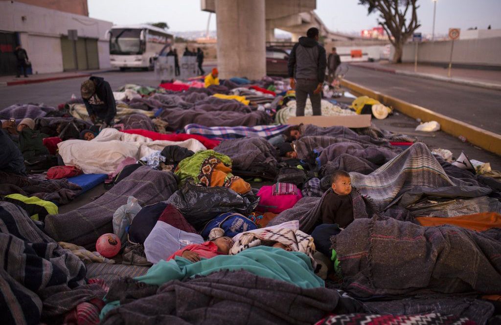Un grupo de migrantes duerme bajo un puente en el cruce fronterizo Chaparral en Tijuana, México, el viernes 23 de noviembre de 2018. Foto: Rodrigo Abd / AP.