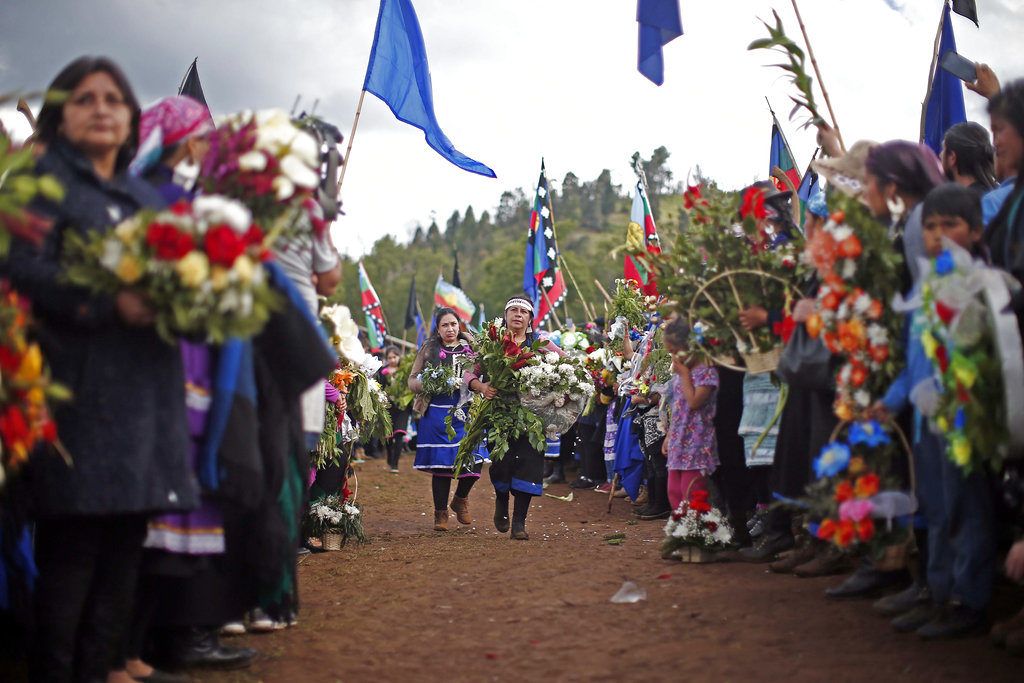 Familiares y amigos de Camilo Catrillanca, un joven indígena mapuche que recibió un disparo en la cabeza cuando la policía perseguía a ladrones de automóviles no identificados, celebran un funeral de ritos mapuches ancestrales en Temuco, Chile, el sábado 17 de noviembre de 2018. (AP Photo/Luis Hidalgo)