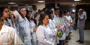 Médicos cubanos esperan para reunirse con el presidente de Cuba, Miguel Díaz-Canel, después de aterrizar en La Habana el viernes 23 de noviembre de 2018. Foto: Desmond Boylan / AP.