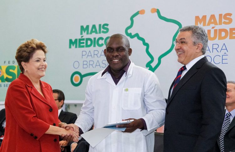 La expresidenta Dilma Rousseff junto a un médico cubano y al Ministro de Salud de su gobierno, Alexandre Padilha, durante la oficialización legal del programa "Más Médicos" en 2013. Foto: Roberto Stuckert Filho/ PR / Archivo.