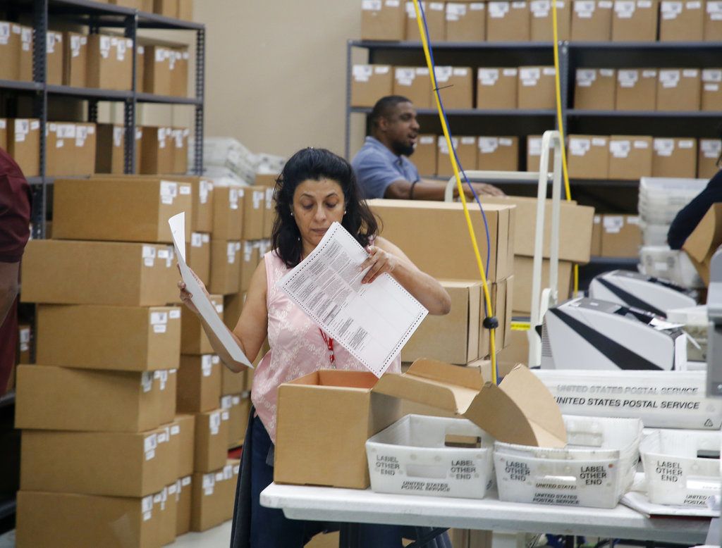 Una trabajadora del Supervisor de Elecciones del Condado de Broward observa una papeleta durante una reunión el viernes 9 de noviembre del 2018, en Lauderhill, Florida. (AP Foto/Joe Skipper)