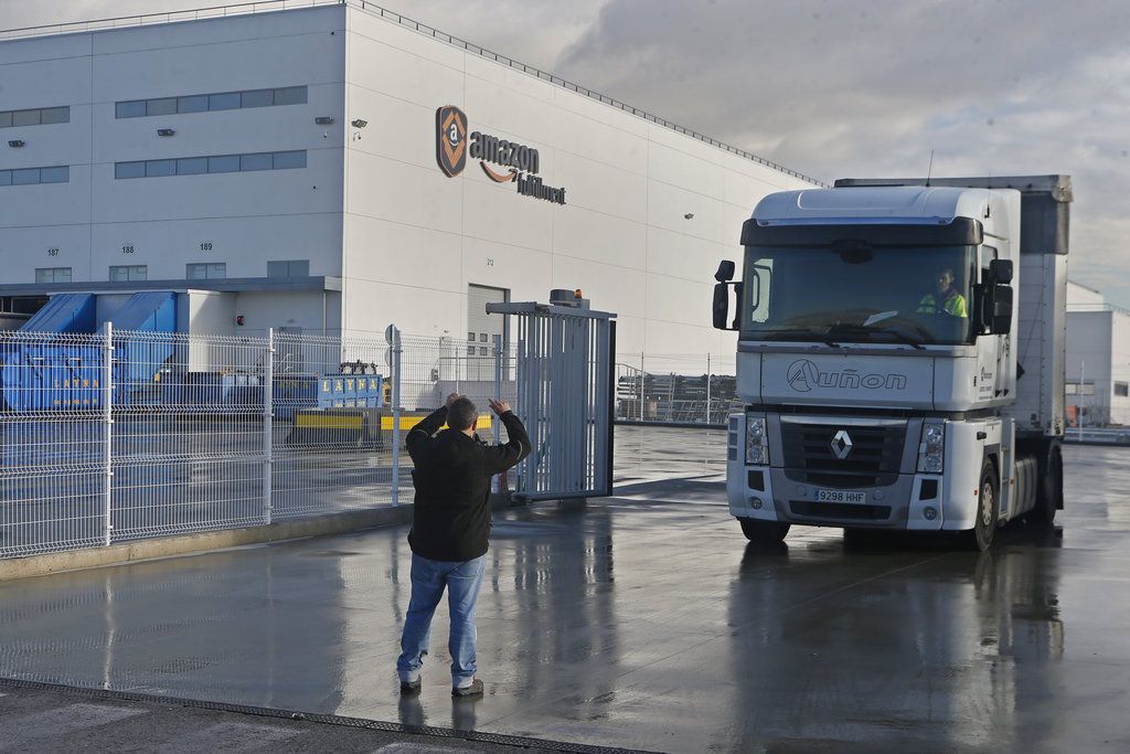Un piquete detiene un camión para hablar con el conductor a su salida de un centro logístico de Amazon a las afueras de Madrid, España, el 22 de noviembre de 2018. (AP Foto/Paul White)